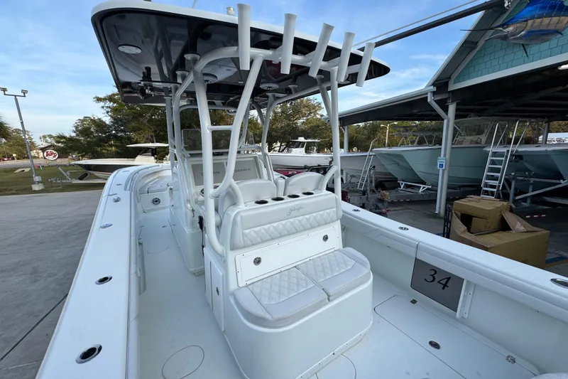 Slide: The Image of 2019 Yellowfin 34 Offshore boat with white seating and rod holders, docked at a marina. - 34