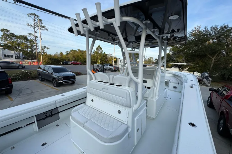 Slide: The Image of 2019 Yellowfin 34 Offshore boat with white seating and console, parked outdoors. - 36