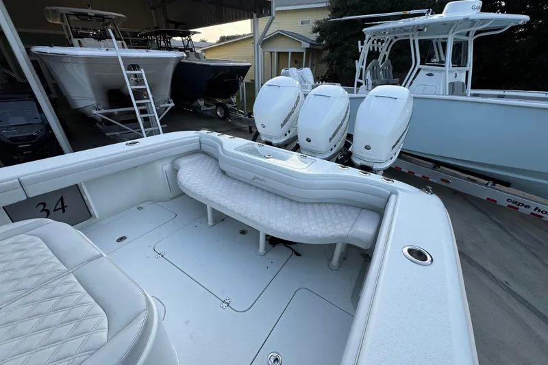 Slide: The Image of 2019 Yellowfin 34 Offshore boat with triple Mercury engines, docked in a marina. - 37