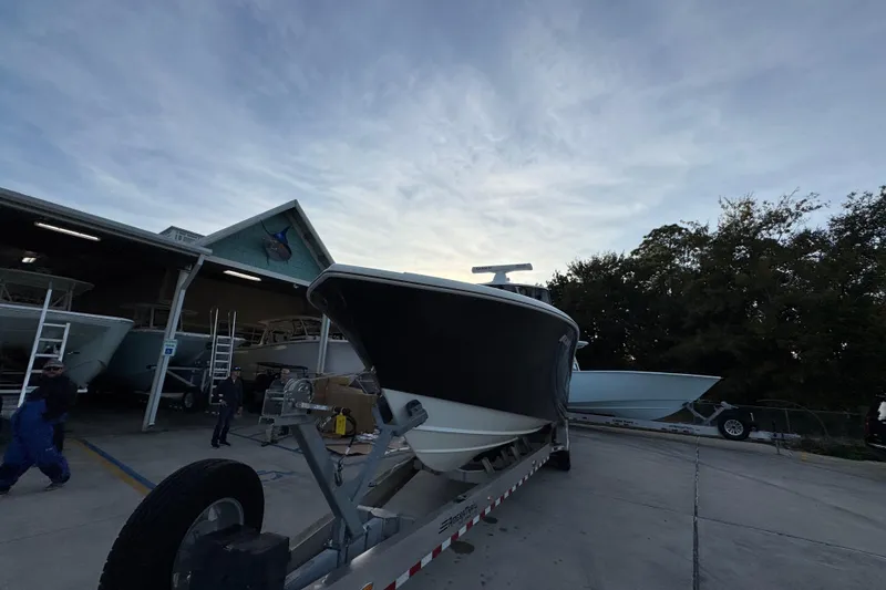 Slide: The Image of 2019 Yellowfin 34 Offshore boat on trailer at marina, under cloudy sky. - 6