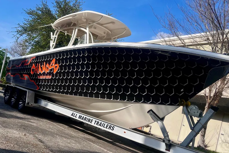 The Image of 2016 Sailfish 290 CC boat on trailer with custom black and orange design. - 1