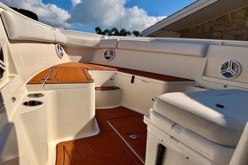 Slide: The Image of 2016 Sailfish 290 CC boat interior with teak flooring and cushioned seating. - 10