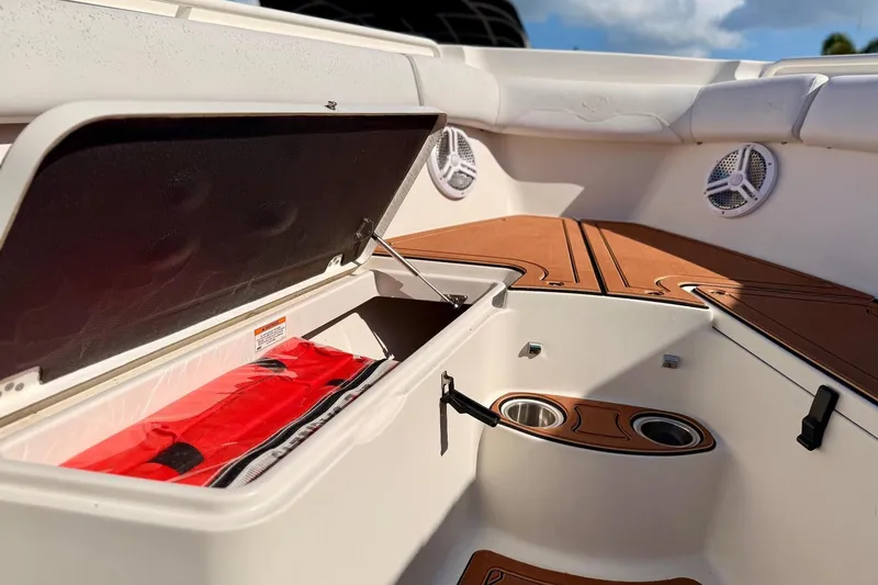 Slide: The Image of 2016 Sailfish 290 CC boat interior with open storage compartment and cup holders. - 11