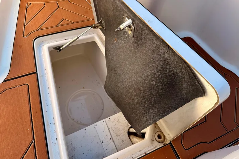 Slide: The Image of Open storage compartment on 2016 Sailfish 290 CC boat with brown deck. - 16