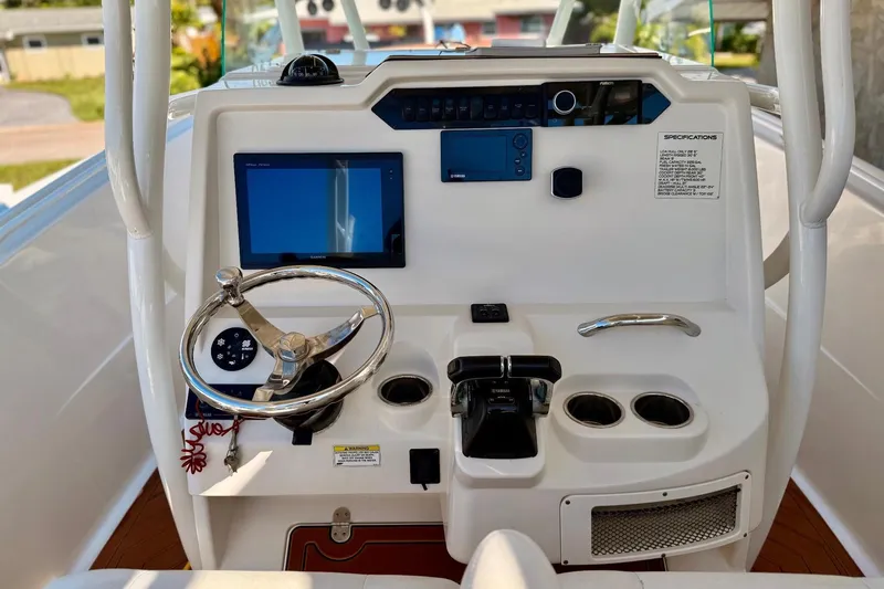 Slide: The Image of 2016 Sailfish 290 CC boat dashboard with steering wheel, controls, and navigation display. - 20
