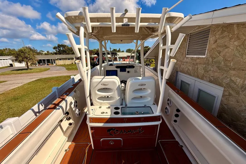 Slide: The Image of 2016 Sailfish 290 CC boat interior with seating and rod holders under a blue sky. - 28