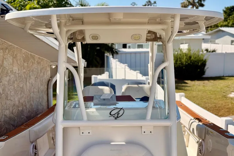 Slide: The Image of 2016 Sailfish 290 CC boat with T-top and console, docked in a residential area. - 29