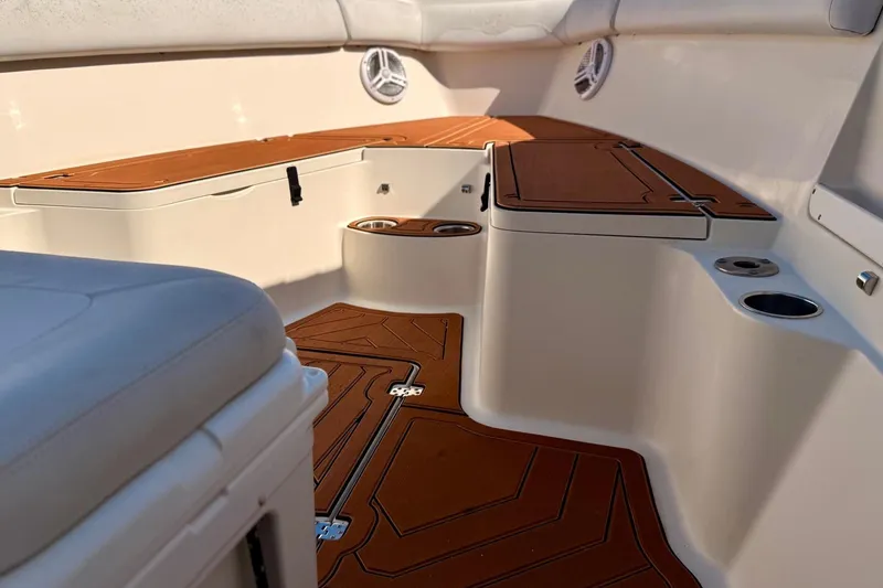 Slide: The Image of 2016 Sailfish 290 CC boat interior with cushioned seating and cup holders. - 9