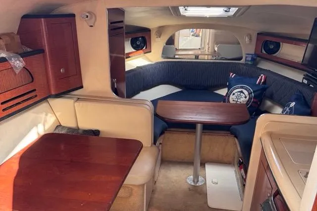 Slide: The Image of Interior of 2005 Sea Ray 280 Sundancer boat with cozy seating and wooden tables. - 13