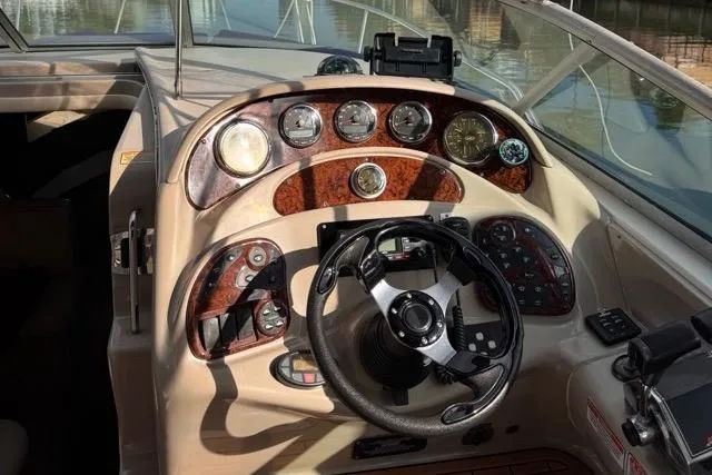 Slide: The Image of 2005 Sea Ray 280 Sundancer helm with wood accents and modern controls. - 19