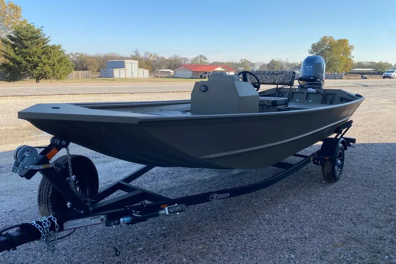 Slide: The Image of 2026 G3 Gator Tough 17 CCJ boat on trailer, outdoors, side view. - 2