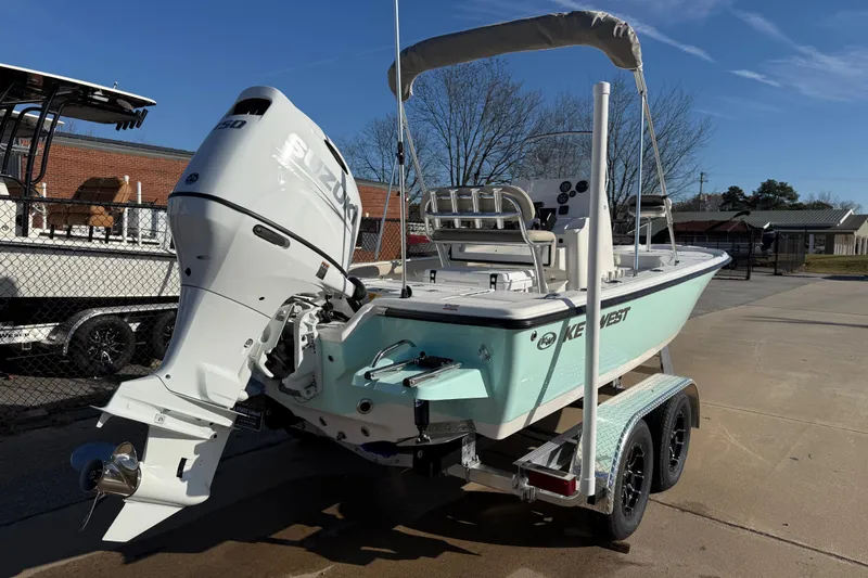 Slide: The Image of 2026 Key West 210 Bay Reef boat with Suzuki engine on trailer, parked outdoors. - 2