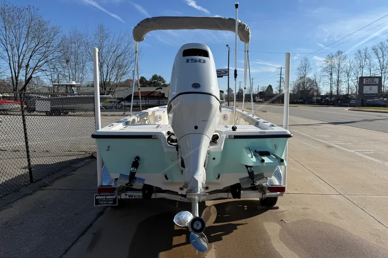 Slide: The Image of 2026 Key West 210 Bay Reef boat with outboard motor, parked on a sunny day. - 3