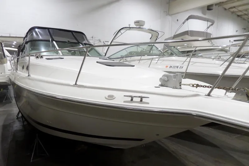 The Image of 1994 Searay 300 Weekender boat in indoor storage, showcasing sleek design and white exterior. - 0