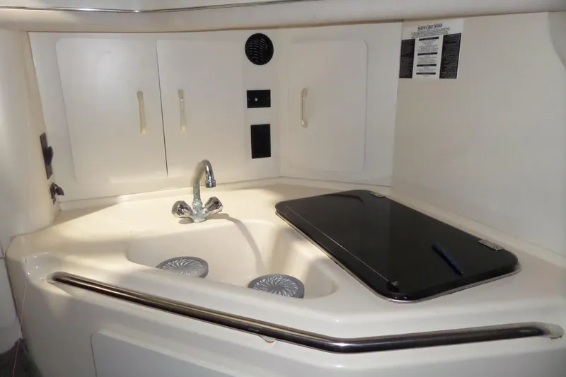 Slide: The Image of 1994 Searay 300 Weekender boat kitchenette with sink and storage cabinets. - 12