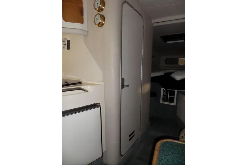 Slide: The Image of Interior of 1994 Searay 300 Weekender boat, featuring cabin door and compact kitchen area. - 14