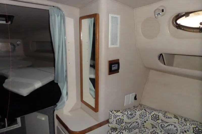 Slide: The Image of Interior cabin of 1994 Searay 300 Weekender boat with bed, mirror, and seating area. - 15