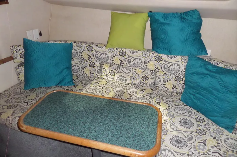 Slide: The Image of 1994 Searay 300 Weekender cabin interior with patterned seating and colorful cushions. - 21