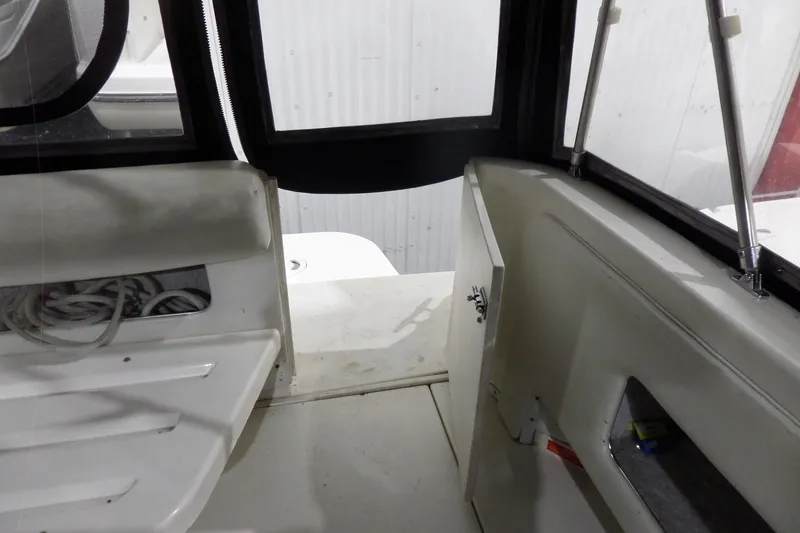 Slide: The Image of 1994 Searay 300 Weekender boat interior with open storage compartment and coiled rope. - 38