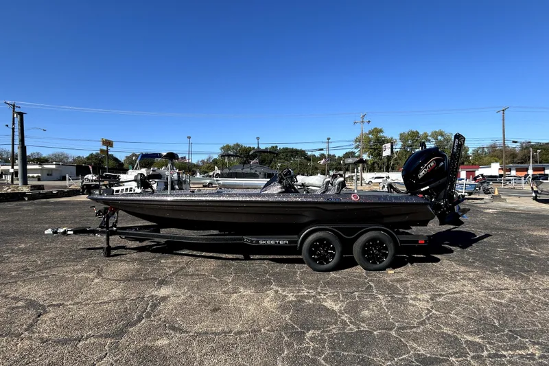 Slide: The Image of 2026 Skeeter ZXE21 boat on trailer in parking lot under clear blue sky. - 3