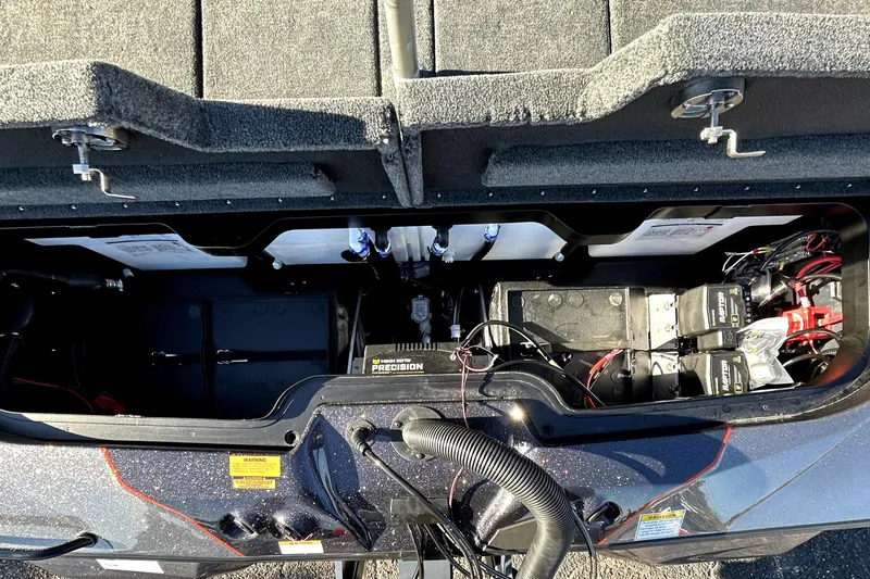 Slide: The Image of Open battery compartment of 2026 Skeeter ZXE21 boat, showcasing wiring and components. - 36