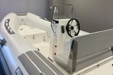 Slide: The Image of 2023 Flexboat SR15 inflatable boat with steering console and seating, in a showroom setting. - 5