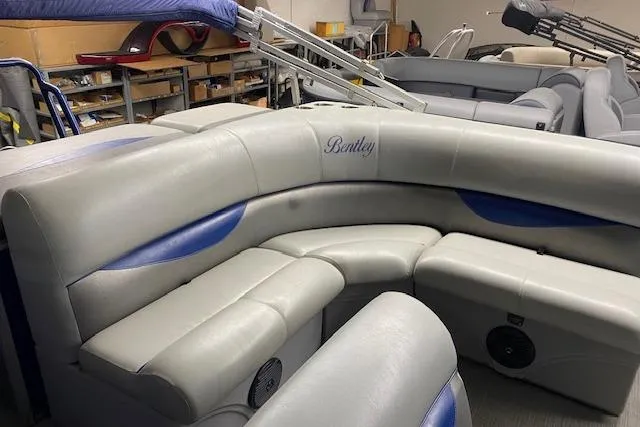 Slide: The Image of 2018 Bentley Pontoons 220/223 Cruise interior with gray and blue seating in a showroom. - 4