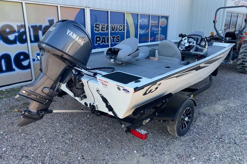 Slide: The Image of 2026 G3 Sportsman 1610 boat with Yamaha motor, parked on gravel near service center. - 6