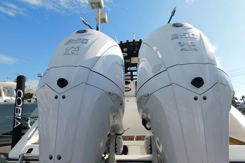 Slide: The Image of 2026 Cobia 265 Center Console boat deck with open hatch and wood-style flooring. - 24