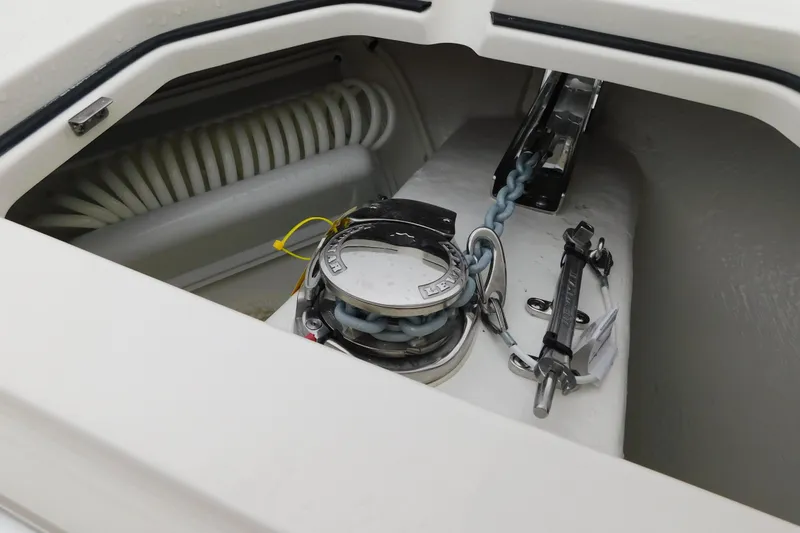 Slide: The Image of Anchor compartment of 2026 Cobia 265 Center Console boat, featuring chain and winch. - 34