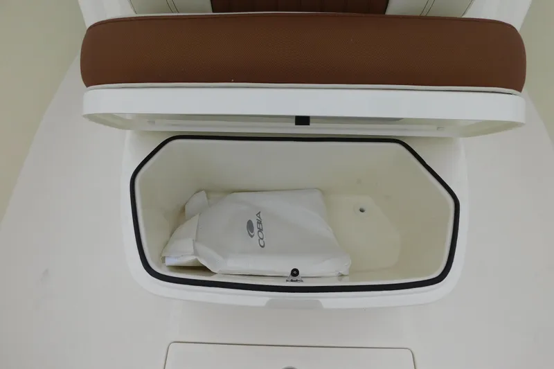 Slide: The Image of 2026 Cobia 265 Center Console storage compartment with cushion and branded bag. - 35