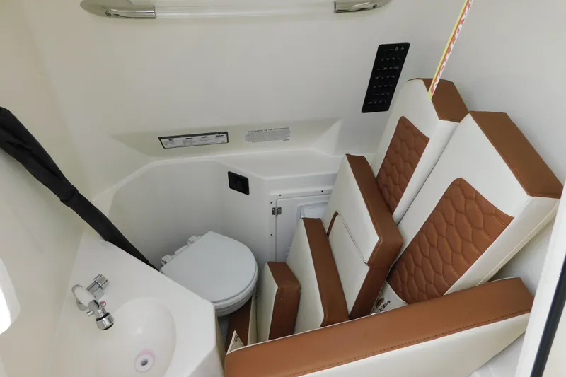 Slide: The Image of 2026 Cobia 265 Center Console interior with compact bathroom and seating. - 36