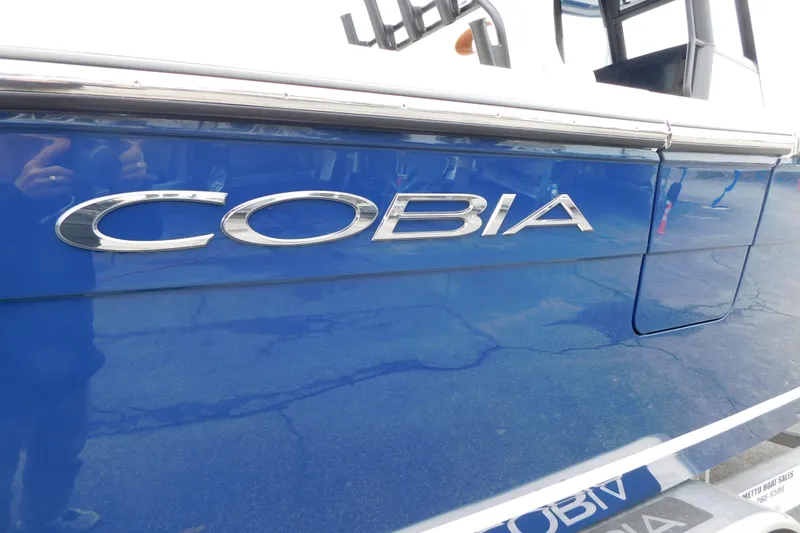 Slide: The Image of 2026 Cobia 265 Center Console boat with blue exterior and chrome logo. - 45
