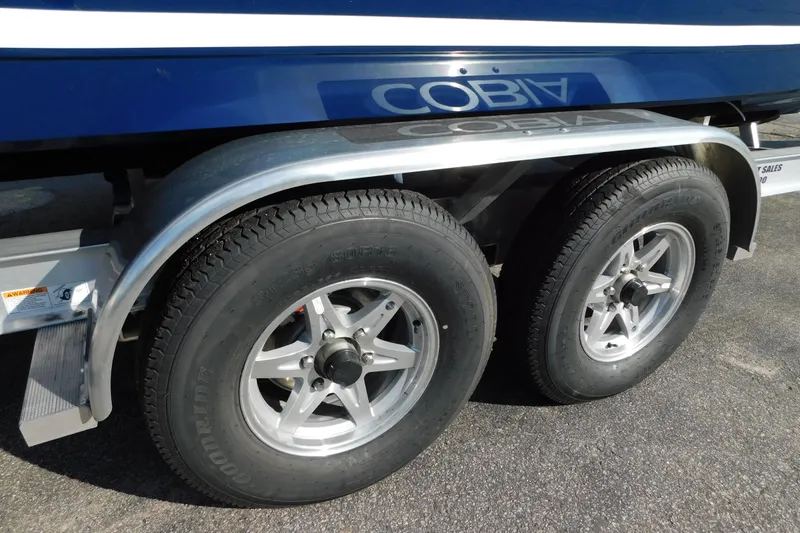 Slide: The Image of 2026 Cobia 265 Center Console boat trailer with dual wheels and blue hull. - 51