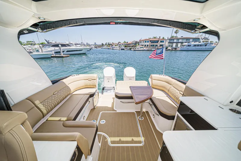 Slide: The Image of 2023 Sea Ray Sundancer 370 OB interior with spacious seating and scenic marina view. - 16