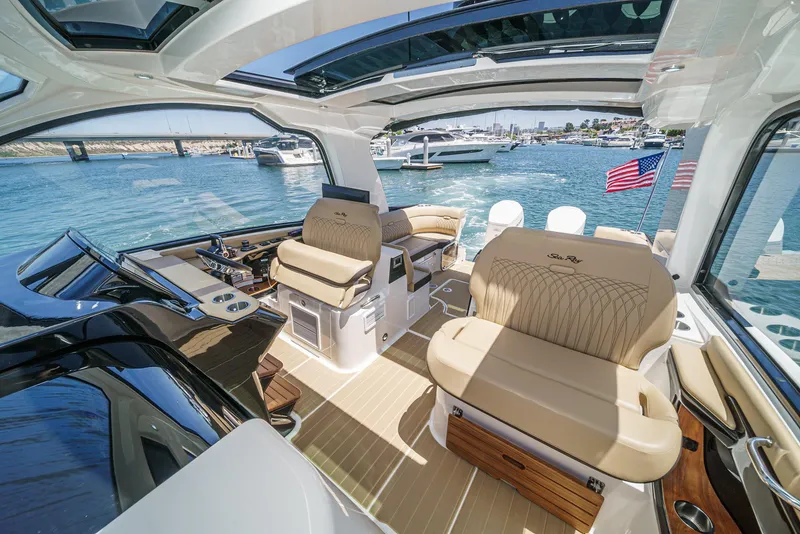 Slide: The Image of 2023 Sea Ray Sundancer 370 OB interior with luxurious seating and scenic marina view. - 23