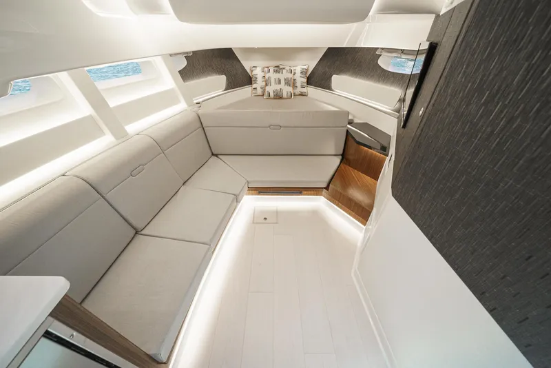 Slide: The Image of 2023 Sea Ray Sundancer 370 OB cabin interior with modern seating and ambient lighting. - 28