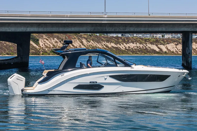 Slide: The Image of 2023 Sea Ray Sundancer 370 OB cruising under a bridge on a sunny day. - 7