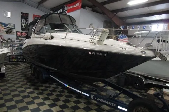 The Image of 2006 Sea Ray 300 Sundancer boat on trailer in indoor showroom. - 1