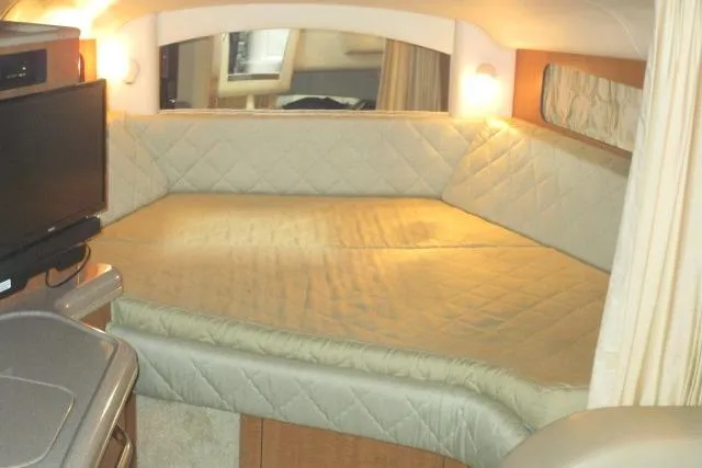 Slide: The Image of 2006 Sea Ray 300 Sundancer cabin interior with cozy bed and TV. - 13