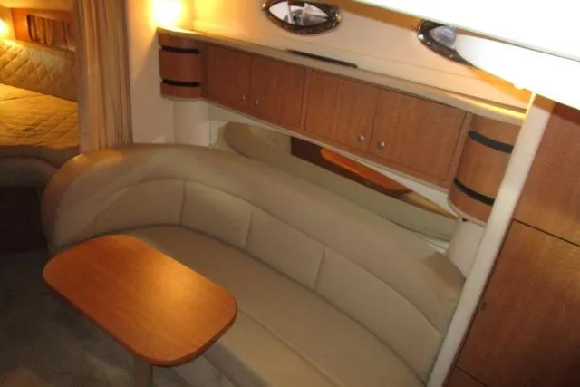 Slide: The Image of Interior of 2006 Sea Ray 300 Sundancer with beige seating and wooden cabinetry. - 14
