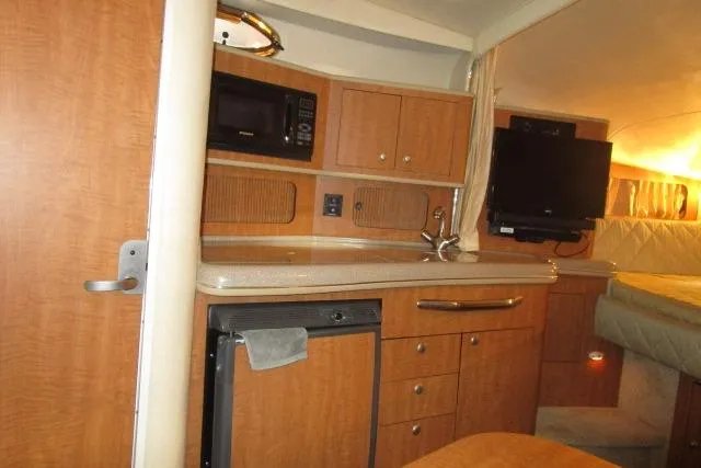 Slide: The Image of 2006 Sea Ray 300 Sundancer cabin with kitchenette, microwave, and TV. - 15