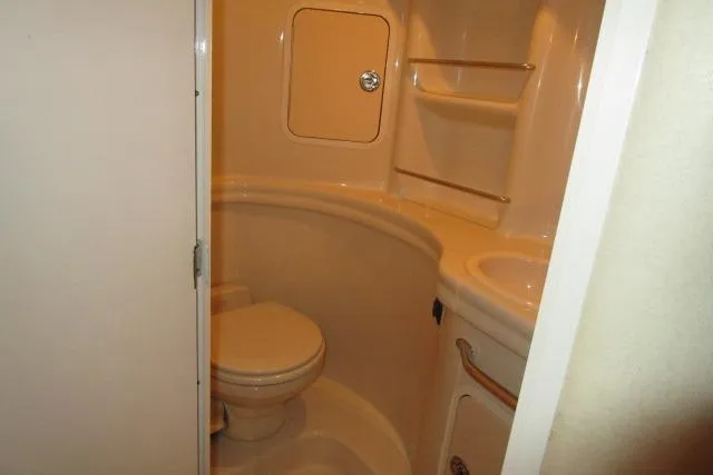 Slide: The Image of Bathroom interior of 2006 Sea Ray 300 Sundancer boat, featuring toilet and sink. - 16