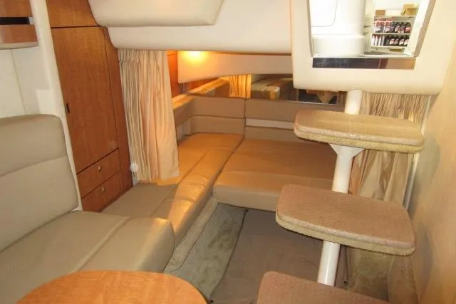 Slide: The Image of Interior of 2006 Sea Ray 300 Sundancer, featuring cozy seating and elegant wood finishes. - 17