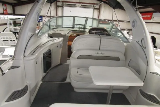Slide: The Image of 2006 Sea Ray 300 Sundancer interior with seating and table in a boat showroom. - 6