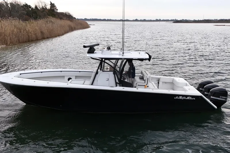 Slide: The Image of 2016 Sea Hunter 35 Tournament boat on calm water, featuring triple Yamaha engines. - 19