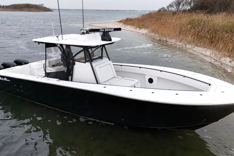 Slide: The Image of 2016 Sea Hunter 35 Tournament boat docked near a sandy shoreline. - 21