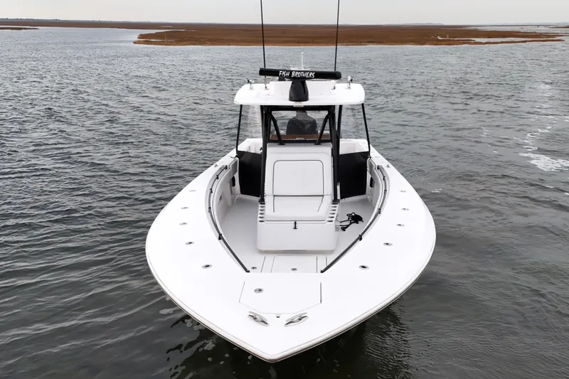 Slide: The Image of 2016 Sea Hunter 35 Tournament boat on calm water, showcasing sleek design and spacious deck. - 5