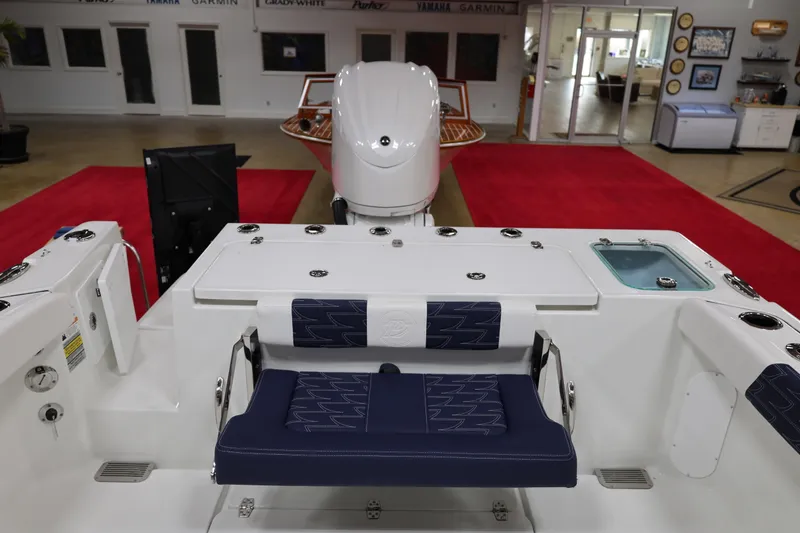 Slide: The Image of 2026 Parker 227 Explorer boat interior with seating and motor, displayed indoors. - 6
