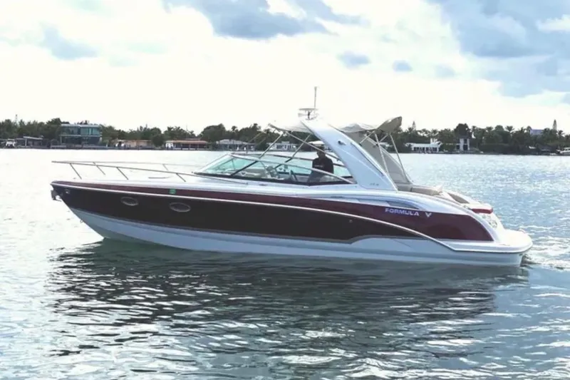 The Image of 2010 Formula 310 Sun Sport boat on calm water under cloudy sky. - 1